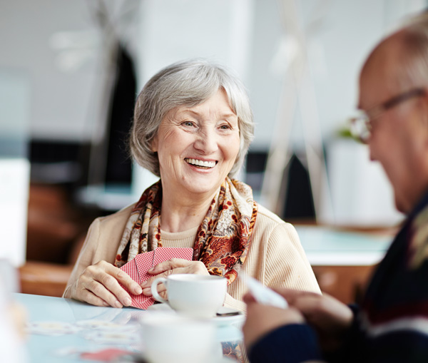 Bridgen Een vrolijke vrouw die aan het kaarten is met andere mensen